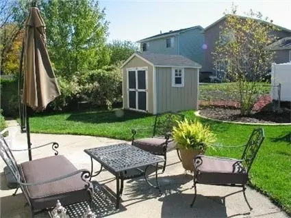 A well kept backyard with outdoor furniture and shed